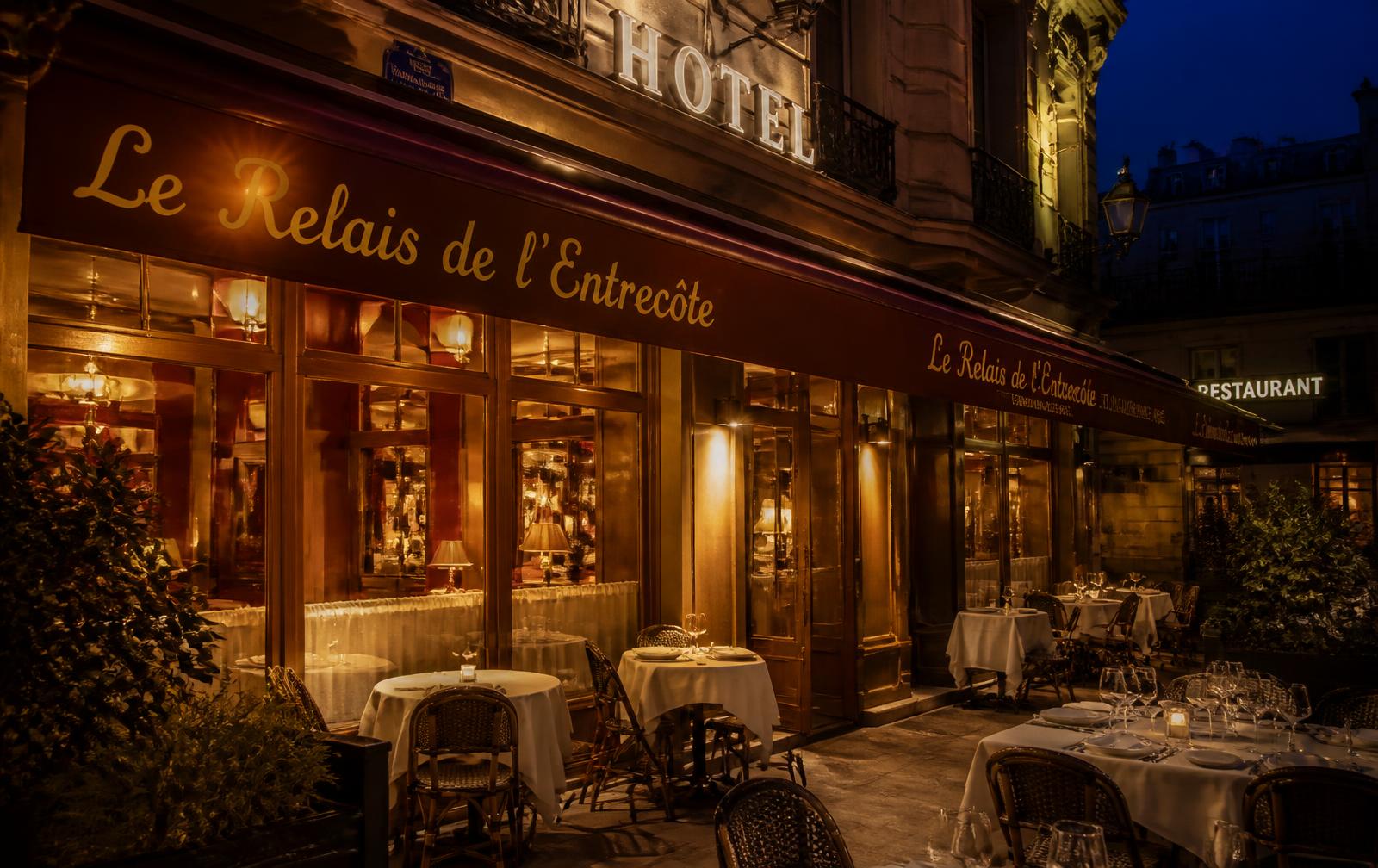 Terrasse d'un hôtel-restaurant parisien éclairée en soirée